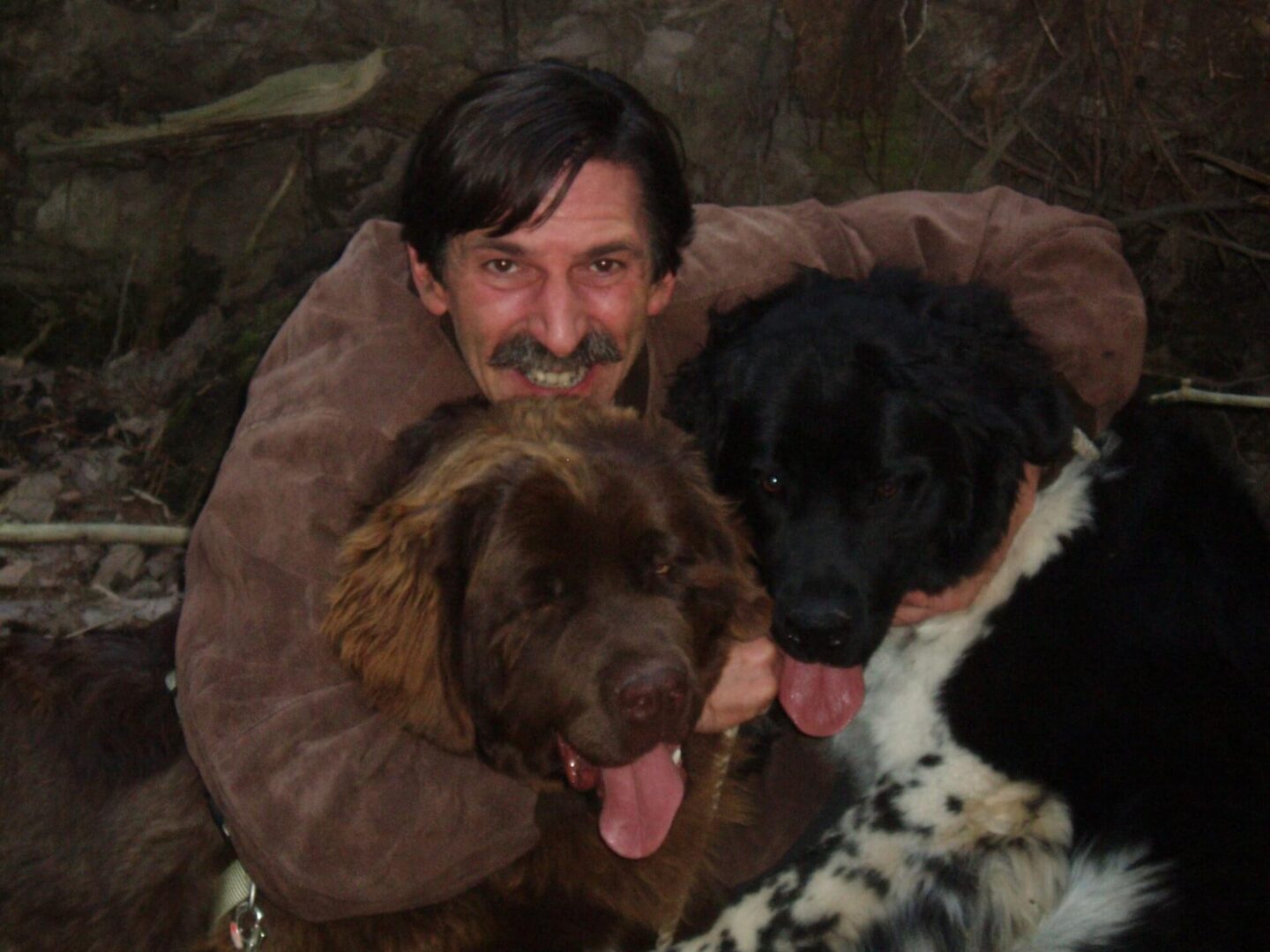 A man with two dogs in his arms.